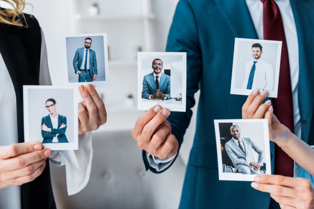 Recruiting Methoden cropped view of recruiters touching photos while standing in office